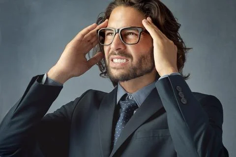 This could explain your recent headache...a handsome young man suffering from a Stock Photos