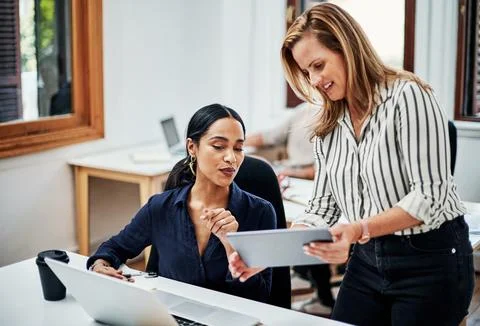 Could you take a look please. an attractive businesswoman helping a female Stock Photos