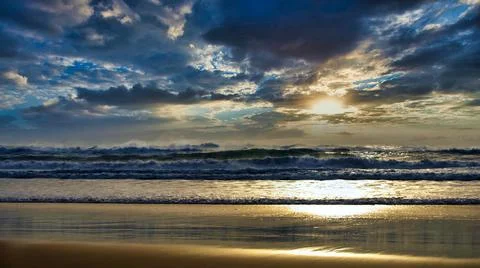 Couldscape Beach Sunset Dramatic cloudy sky in a golden hour Stock Photos