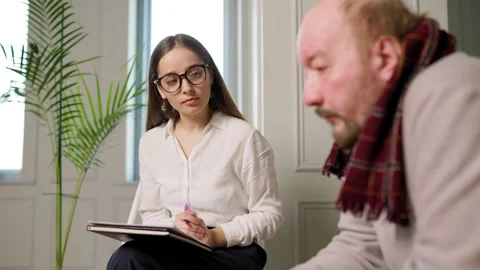 Counseling session between a therapist and a client in a bright room Stock Footage 302970192
