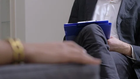 Counseling Therapy Session.Psychologist taking notes during session Stockbeeldmateriaal 104965147