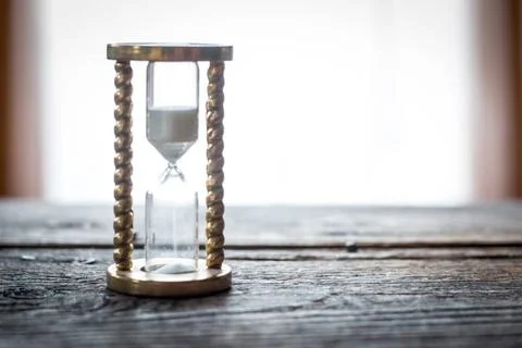 Countdown and time concept: close up of hourglass on rustic wooden desk Ho... Foto stock