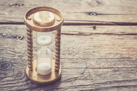 Countdown and time concept: close up of hourglass on rustic wooden desk Ho... Foto stock