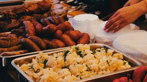 Counter distributes food in plastic plates in which Mushrooms, salad and Stock Footage