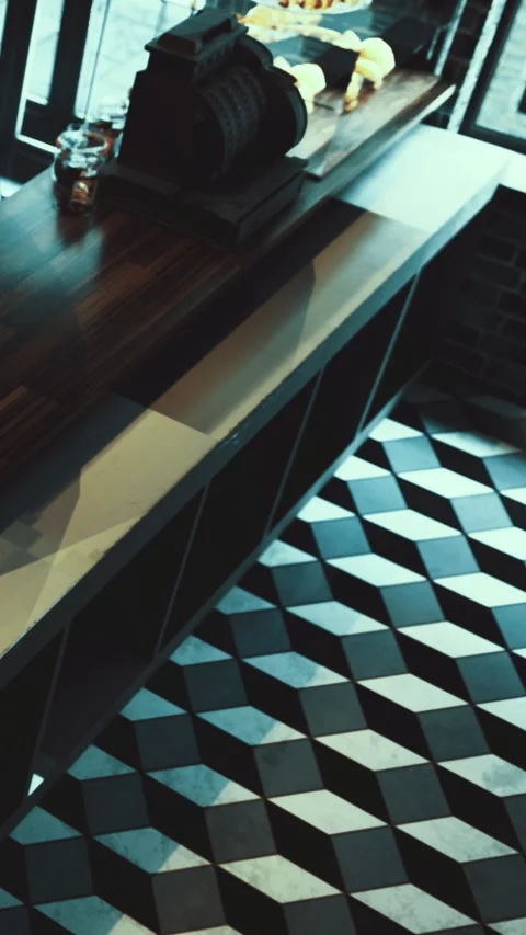 Counter in a modern cafe with patterned floor and light source above Stock Footage 331670637
