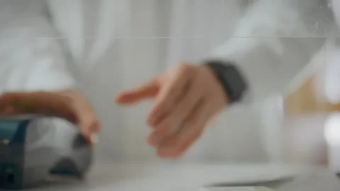 Counter. A pharmacy worker uses experience to provide a terminal for payment Stock Footage 323707105