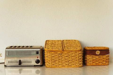 On the counter, there is a toaster alongside two baskets that sit Stock Photos