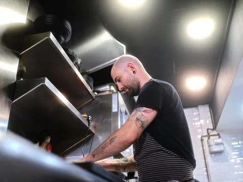 Counter view of a cook working on a kitchen Stock Photos