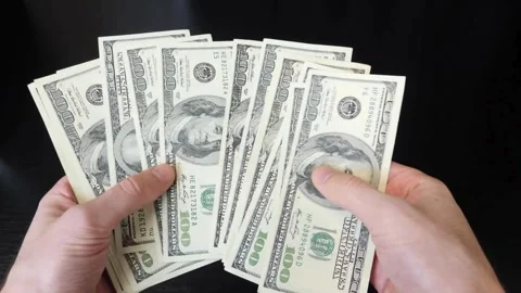 Counting American banknotes on a black background. A man is counting dollar.. Stock Footage 266469720