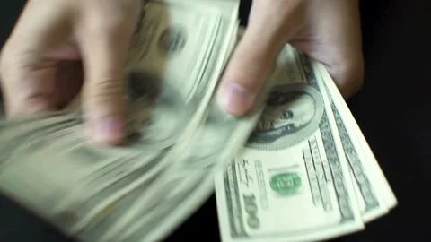 Counting American banknotes on a black background. A man is counting dollar.. Stock Footage 266470375