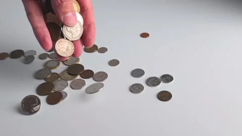 Counting and sorting coins on a table in a quiet room during daytime Stock Footage 341619321