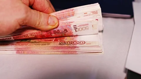 Counting cash in a workspace while handling Russian rubles carefully Stock Footage 328974552