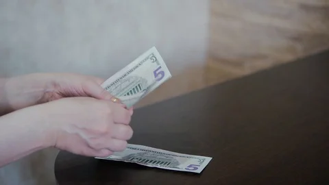 Counting dollars on a wooden table Stock Footage 108054679