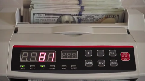 Counting large stack of cash with a money counter machine Stock Footage 298891928