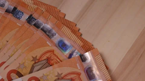 Counting a large stack of euros on a wooden table while planning for a night out Stock Footage 320127121