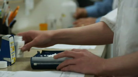 Counting pills at a pharmacy Stock Footage