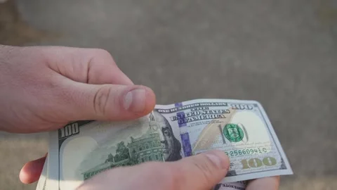 Counting a stack of us dollar bills by a man Stock Footage 296749971
