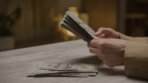 Counting Stack of US Dollars on a Table in Dim Light Stock Footage 295419094