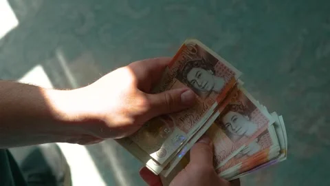 Counting ten pound UK banknotes in daylight. Flipping British currency notes Stock Footage 311572298