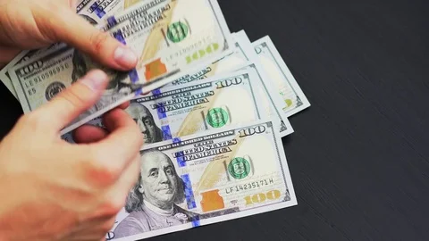 Counting US currency. Man counts money. New dollars in hand. Video stock 82404214