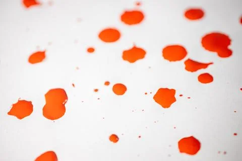 Countless splashes of red paint of various sizes are scattered across. Stock Photos