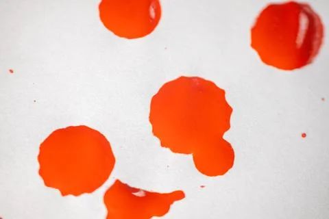 Countless splashes of red paint of various sizes are scattered across. Stock Photos