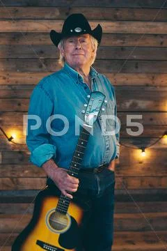 Country And Western Musician Standing With Guitar.
