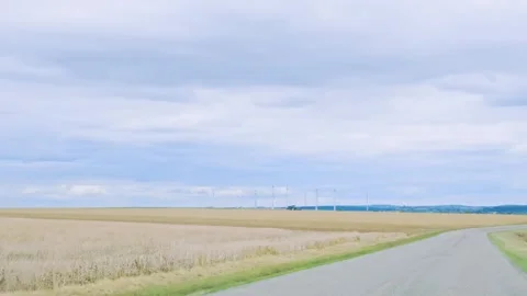 Country Road Curving Through Fields Toward Wind Turbines Stock Footage 345655666