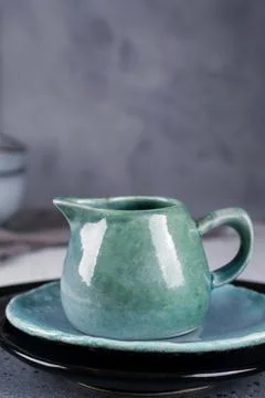 Country, rustic style handcraft kitchenware. Blue ceramic cream jug on grey Stock Photos