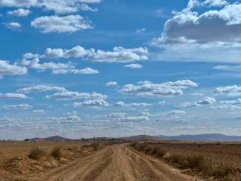 Country side view with empty road, blue sky and white cotton clouds Stock Photos