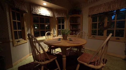 Country-style breakfast nook with round wooden table and chairs Stock Footage 345535199