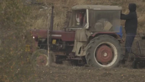 Country tractor passing on the road pulling a wooden wagon loaded with ferti Stock Footage 123758260