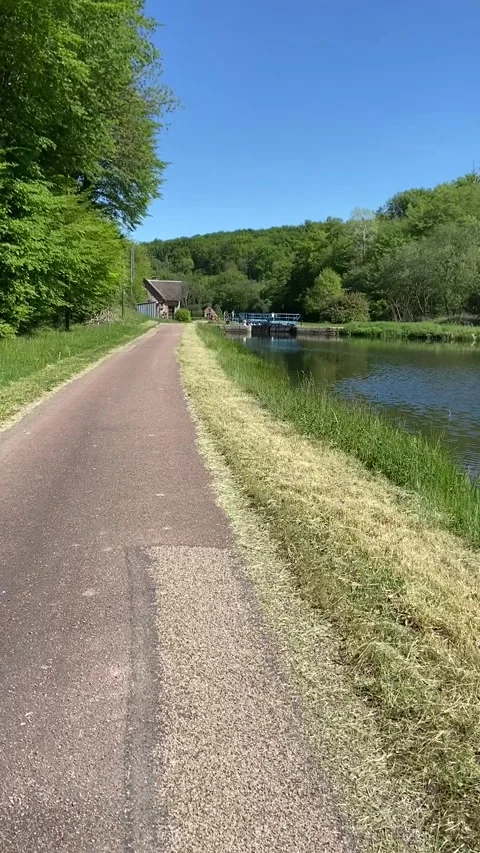 Countryside path lining canal du Nivernais under blue sky Stock Footage 340640179