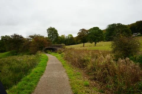 Countryside Path To Stone Arch Bridge With Grazing Sheep, Cromford, England Stock Photos