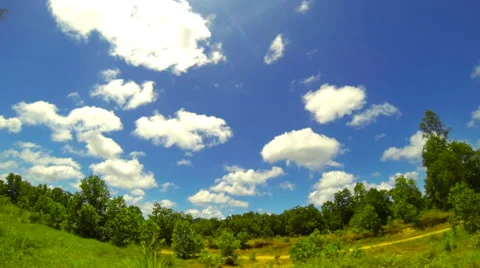 Countryside time lapse with clouds running through blue sky. 4K Stock Footage 40345551
