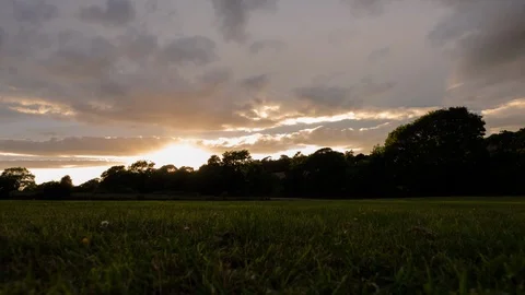 Countryside Timelapse, Sun Sets over Tree Line, Camera Pans 4K Stock Footage 100021076