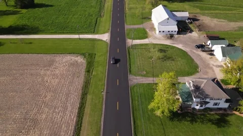 County road through the small town. farm and wind turbines Stock Footage 244351754