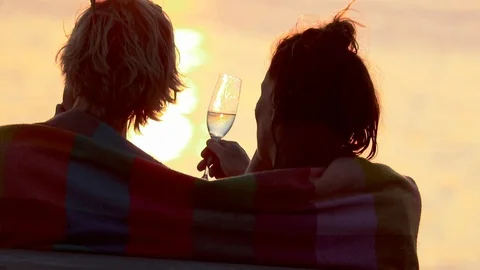 A couople drinking a vine by the sea during the sunset Stock Footage 103482522