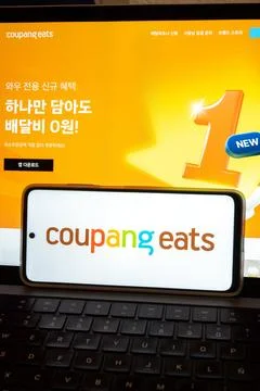 Coupang eats logo appearing on smartphone and laptop screen Stock Photos