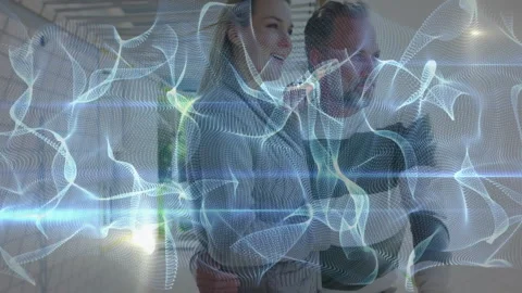 Couple activating tablet in unfinished corridor, generating holographic mesh Stock Footage 312758781