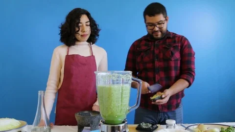 Couple adding avocado to mexican green sauce Stock-Footage 124664720