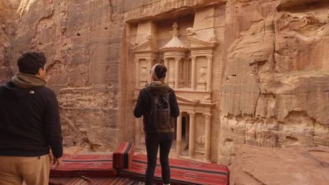 Couple admiring the Treasury of Petra from an elevated viewpoint Stock Footage 250551483