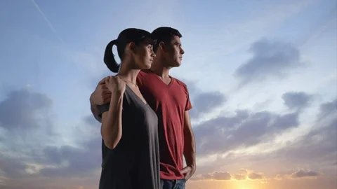 Couple against dramatic sunset Stock Footage 136557182