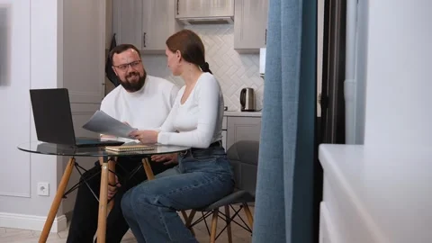 Couple analyzing documents and working on laptop at home 库存影片 317443144