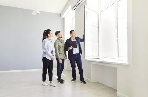 A couple and an agent view an empty house Fotos de archivo