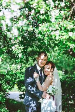 The couple in the Apple trees, looking at camera, a flowering white tree Stock Photos