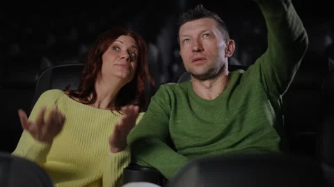 Couple Argues Over Movie Plot While Watching Film Together in Cinema Theater Vídeos de archivo 298028534