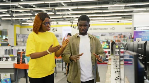 Couple arguing in electronics store while choosing a television Stock Footage 301730997
