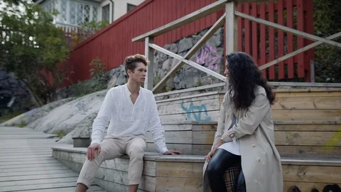 A couple arguing on a tree bench in a park in Stockholm, Sweden. Video stock 115582061