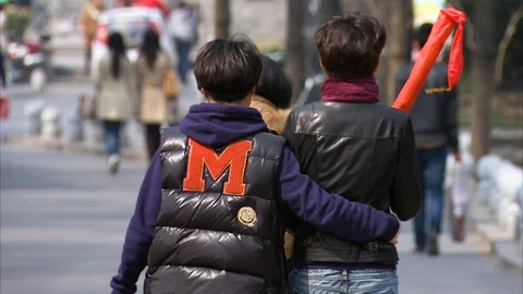 Couple with arm around walking on sidewalk in Beijing Video stock 88832850